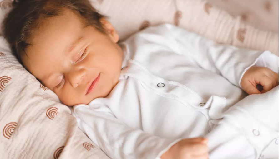bebé vestido de blanco dormido